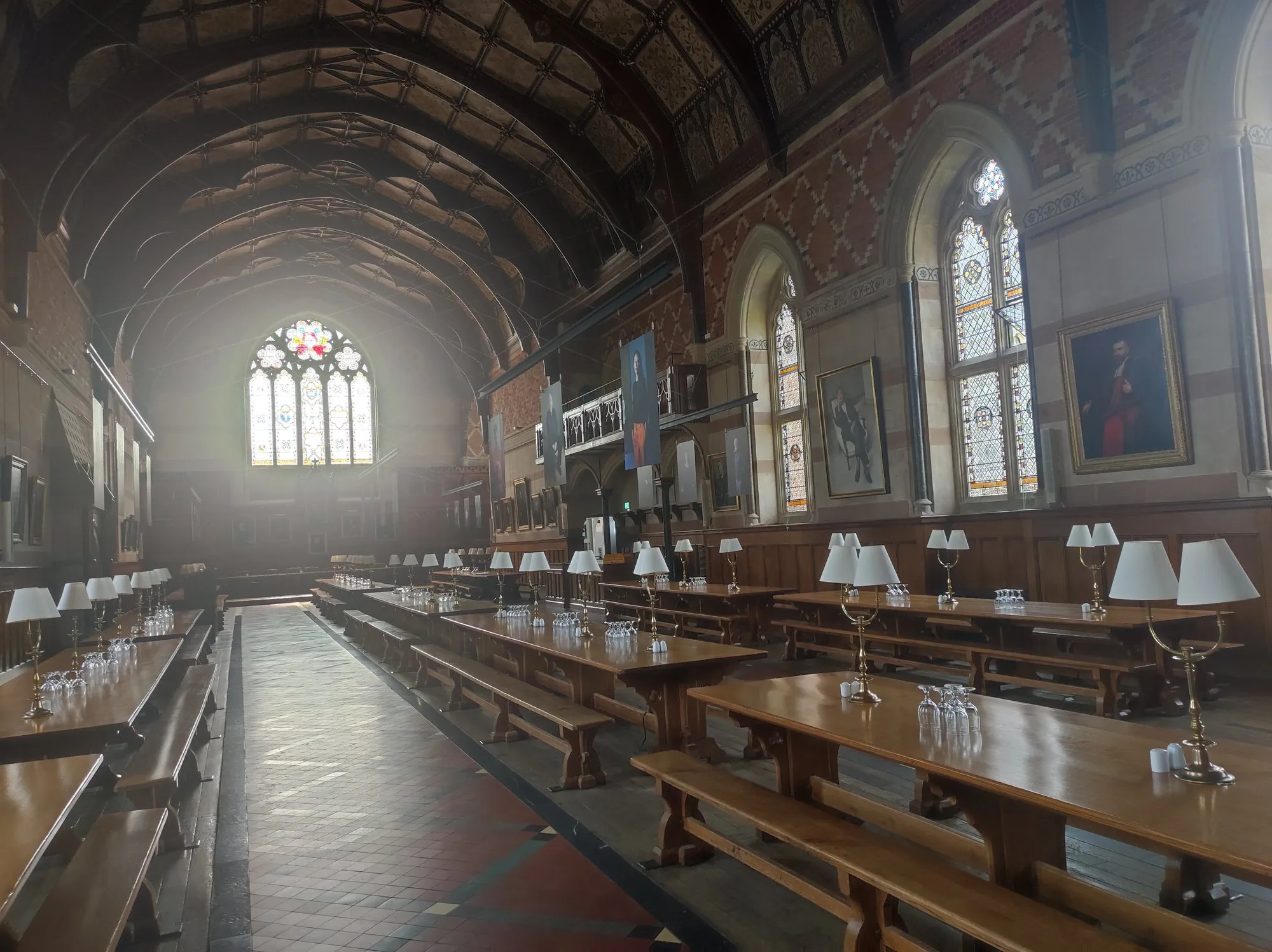 The dining hall of Keble College: stained glass, patterned brick, and long tables